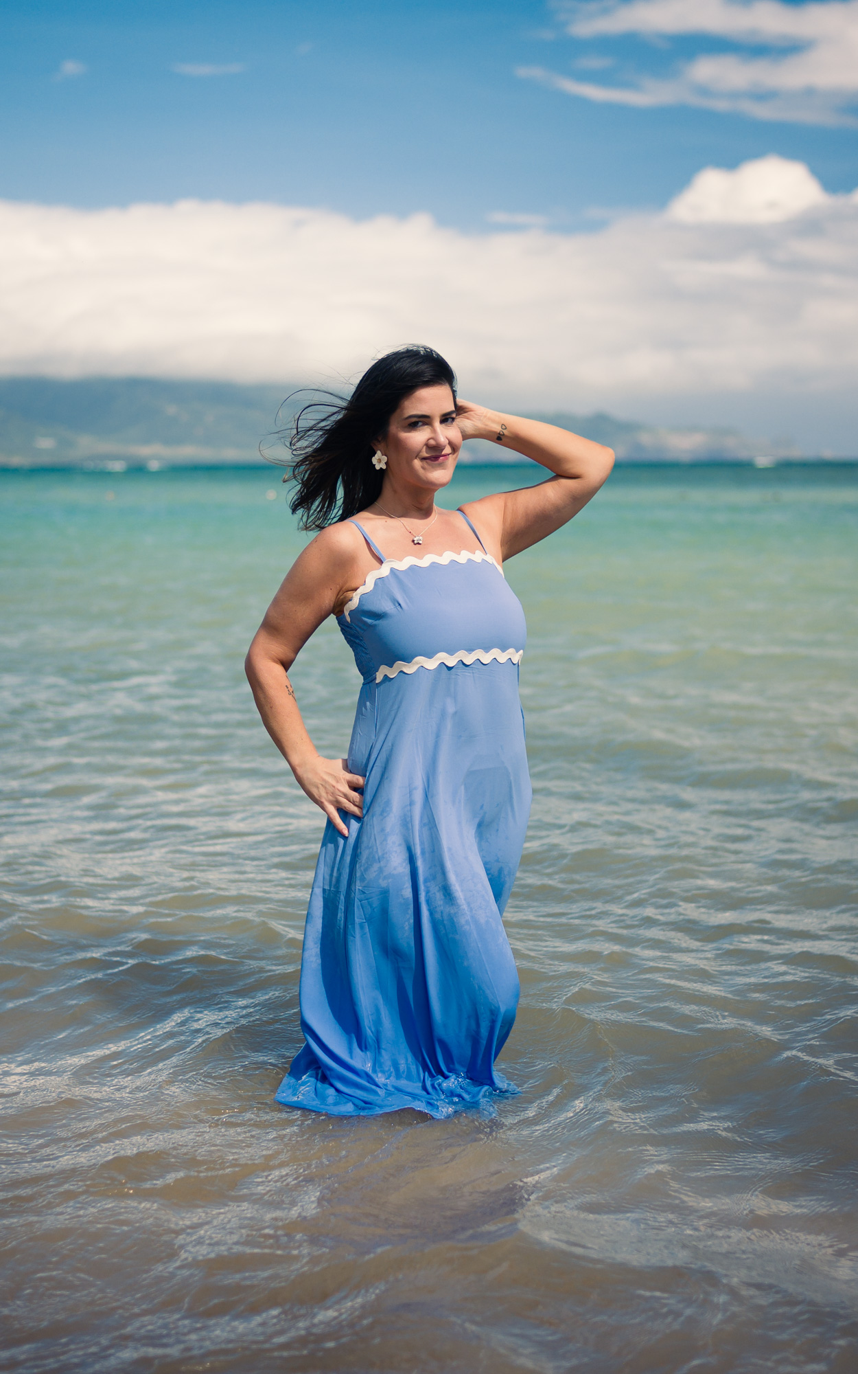 Woman in a blue dress standing in turquoise water off a Maui beach - image by Wailea Photo®
