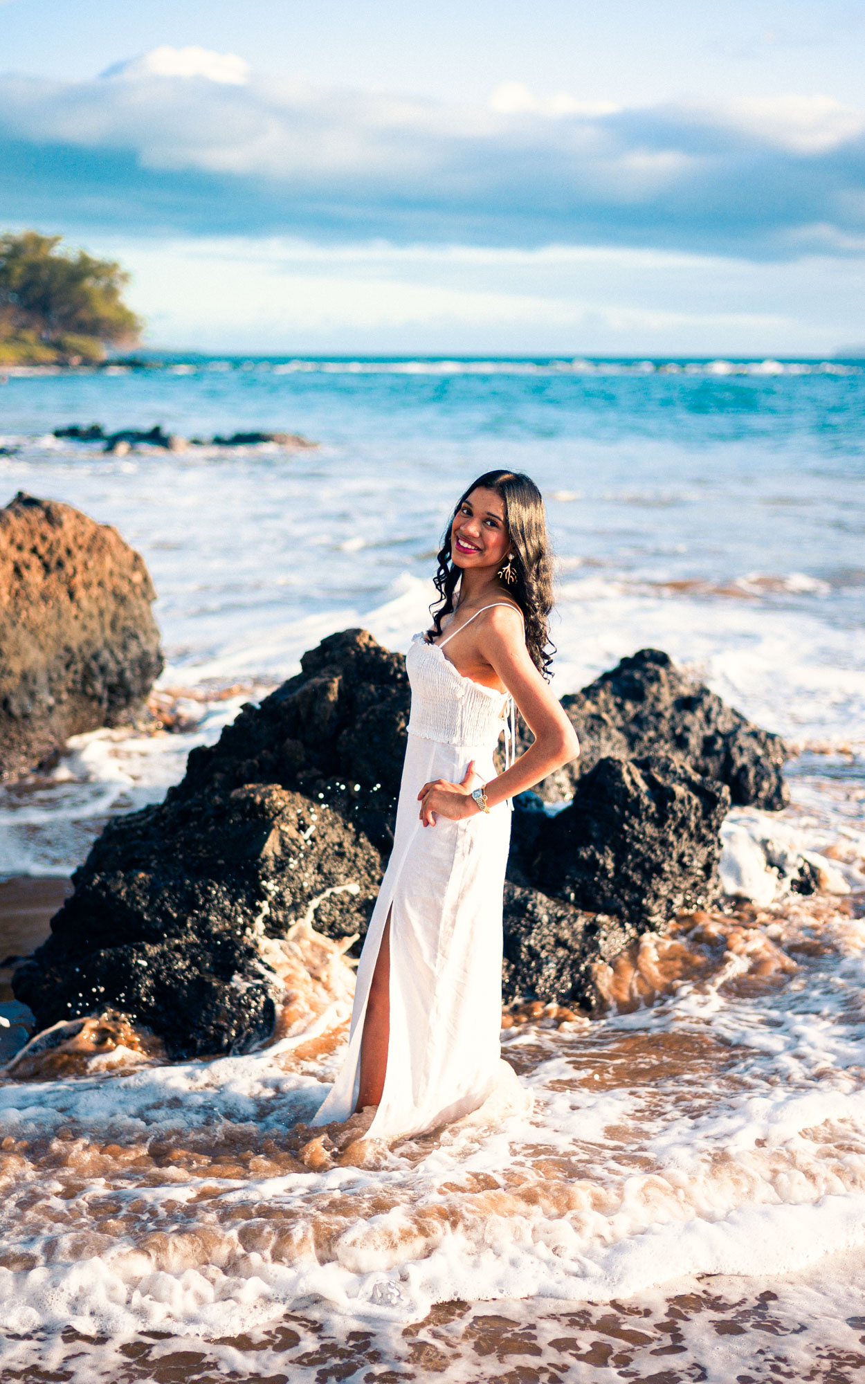 Woman in a white dress beside lava rock in the shallows in South Maui - image by Wailea Photo®