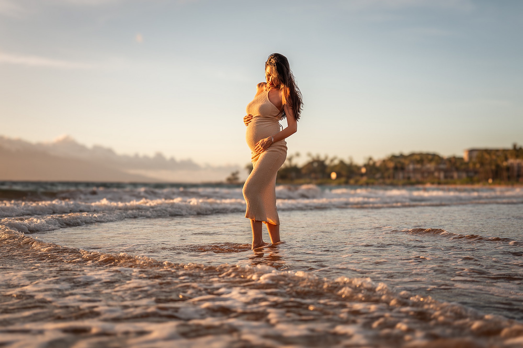 An expectant mother at sunset on the beach near the Four Seasons Resort Maui