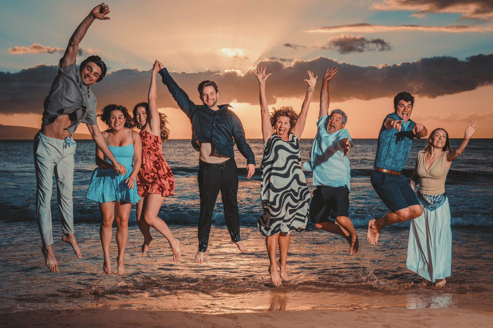 A multi-generation family jumping for joy on a Wailea beach at sunset