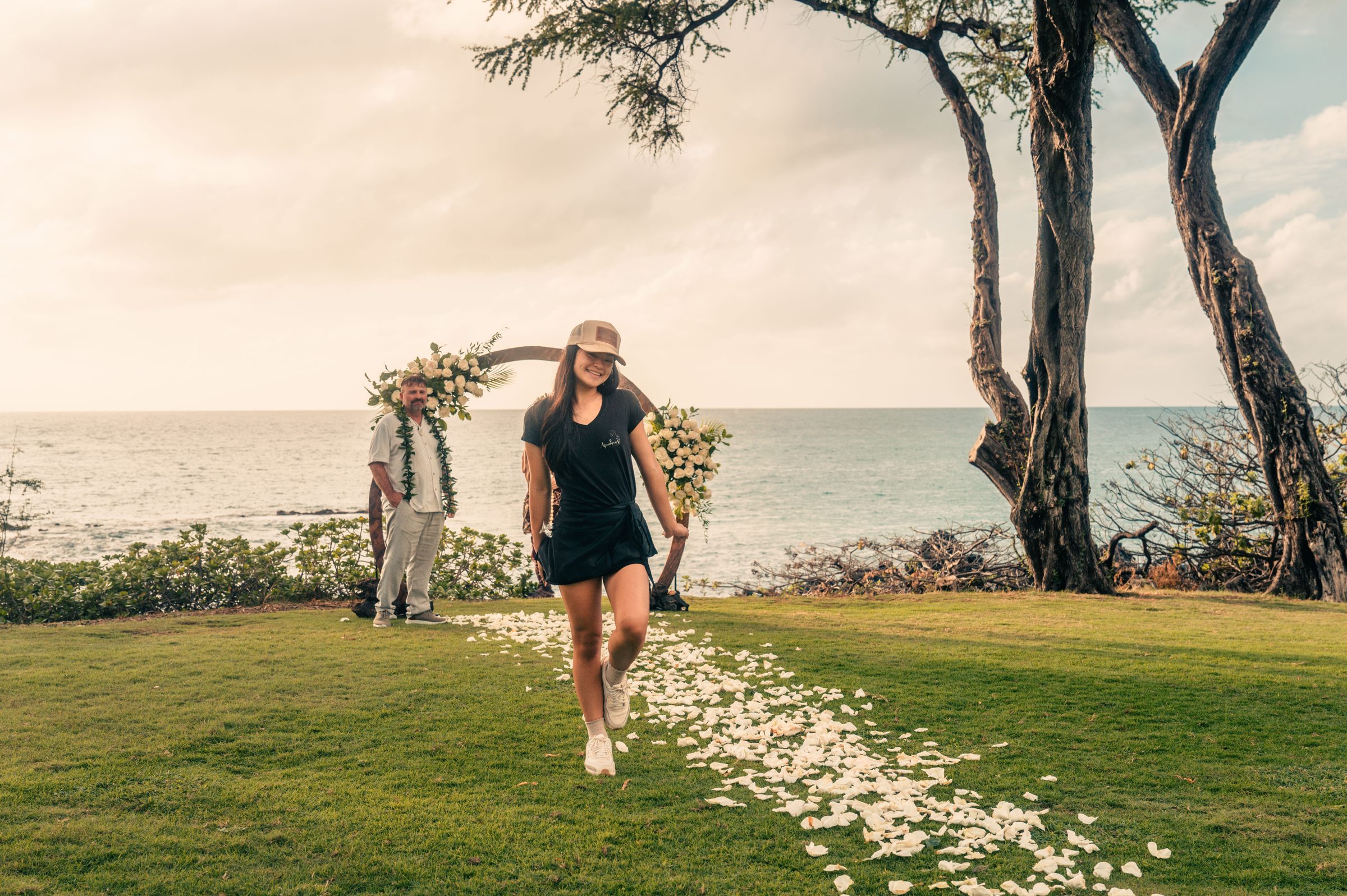 Mya Ige of Apuakea Weddings holding a fresh bouquet on a Maui beach at sunset