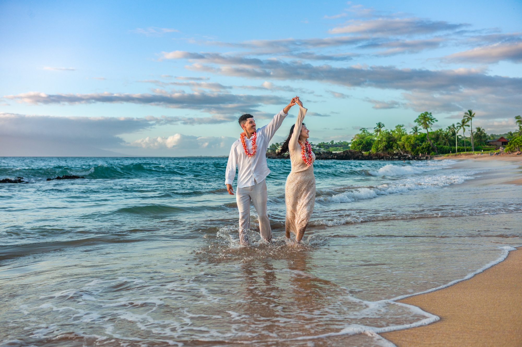 A couple dancing in the shallow surf at sunset on a Wailea beach in Maui