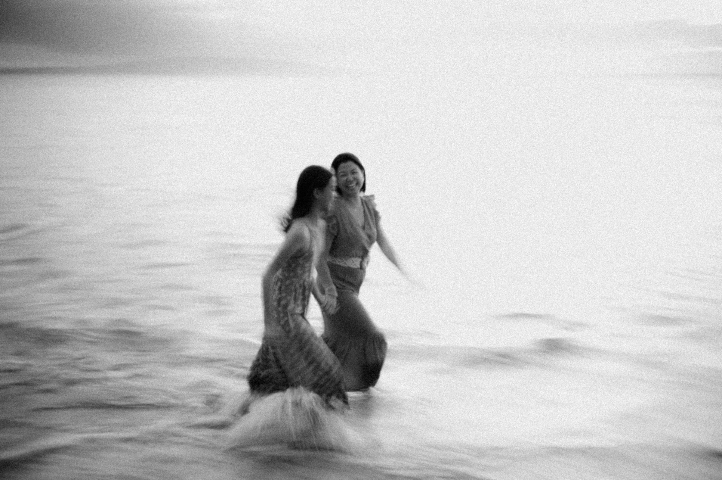 Soft black-and-white portrait of a couple embracing on a Maui beach