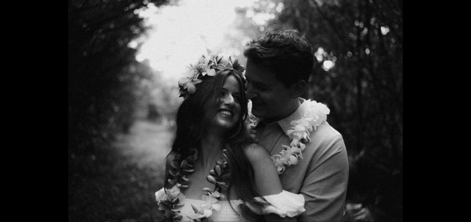 Couple laughing together wearing flower lei in black and white