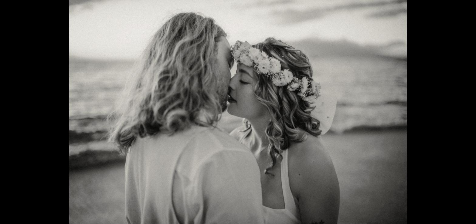 Couple sharing a kiss, the bride wearing a flower crown, in black and white