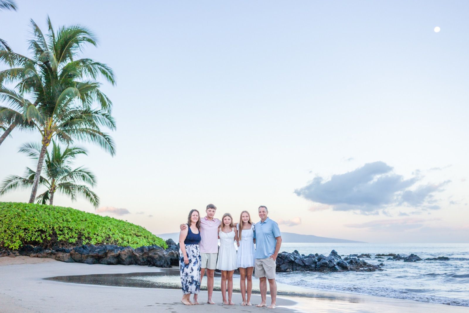 A family together on a Wailea beach during a quiet Maui sunrise