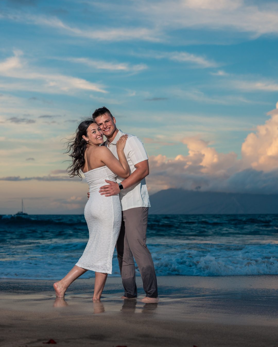 A couple on the beach near the Four Seasons Resort Maui at sunset