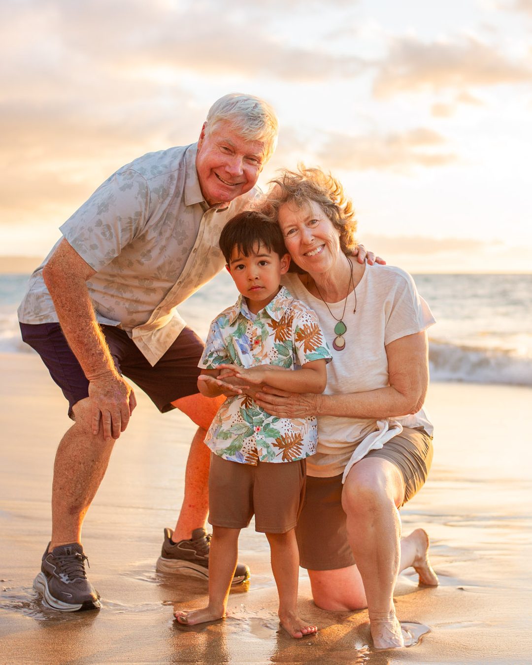 Grandparents and their grandchild at sunset near the Four Seasons Resort Maui
