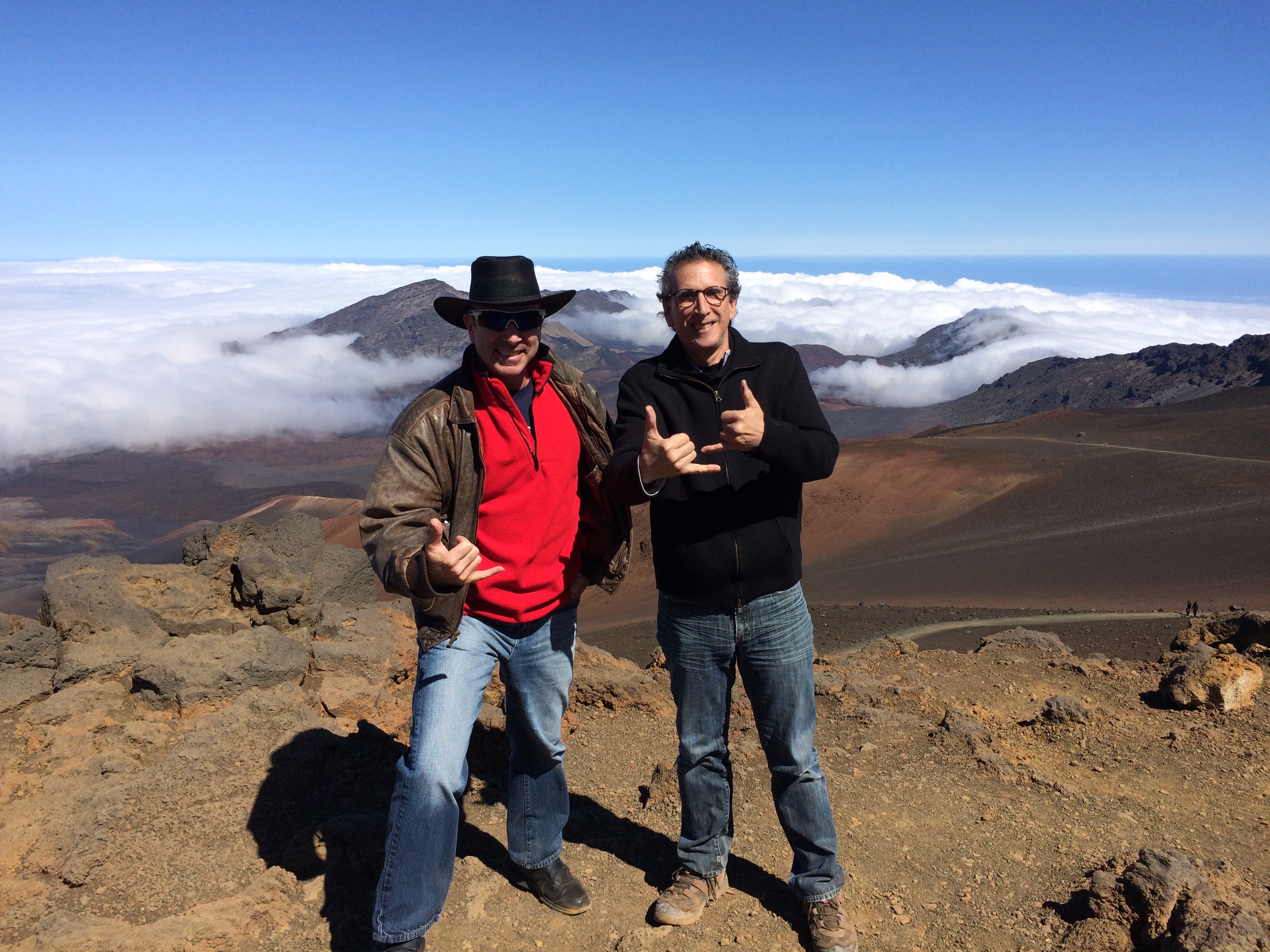 Two visitors greeting the view from the Haleakalā summit