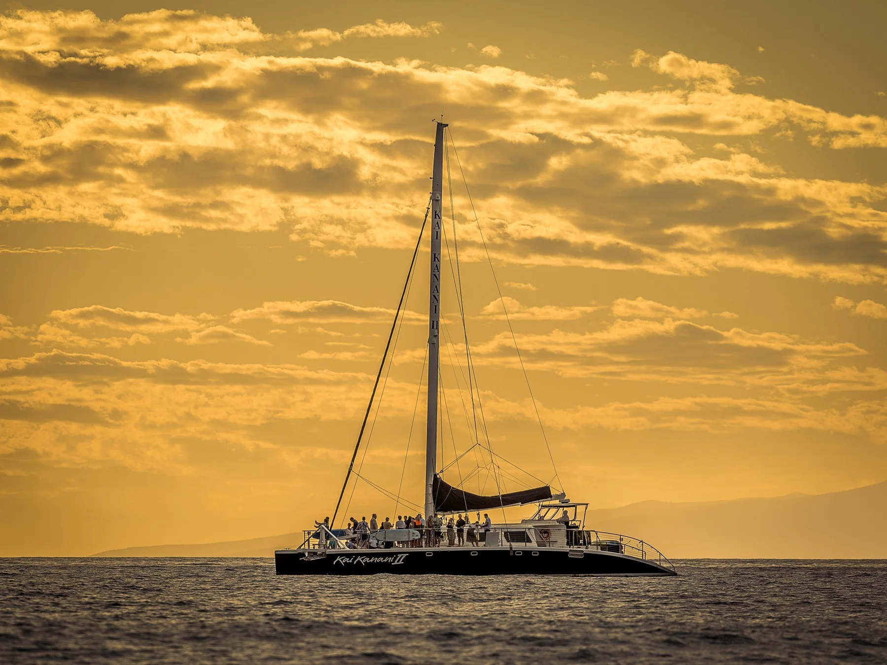 Kai Kanani II catamaran sailing at sunset off the coast of Makena, Maui