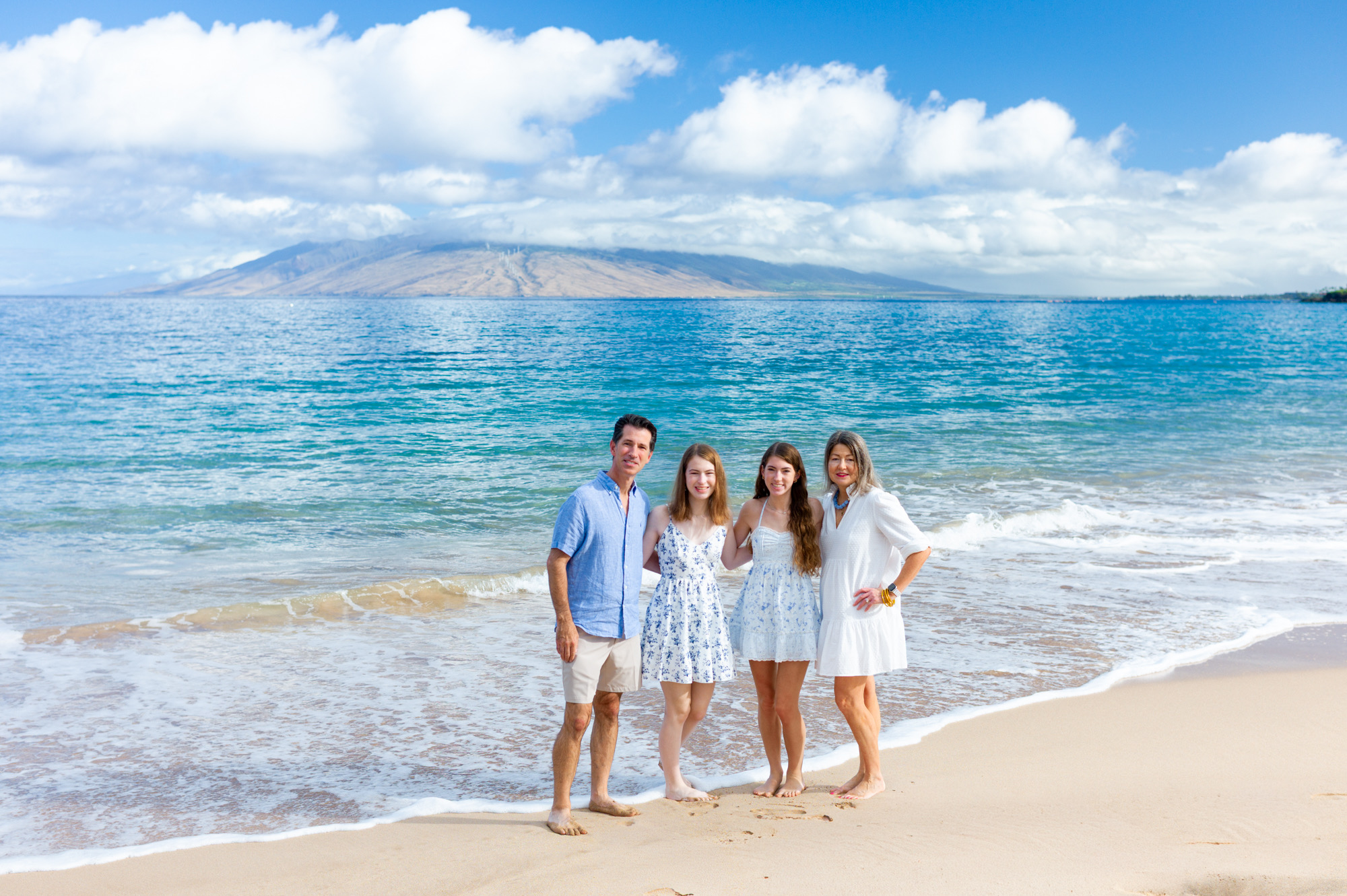 Family in turquoise and light clothing photographed on a Maui beach
