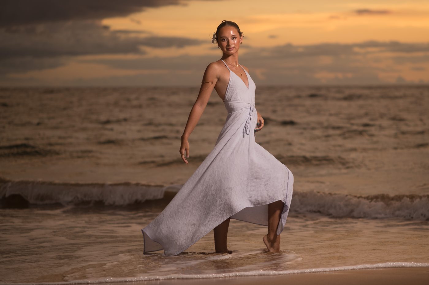 A senior dancer mid-step in the shallows at dusk in Wailea