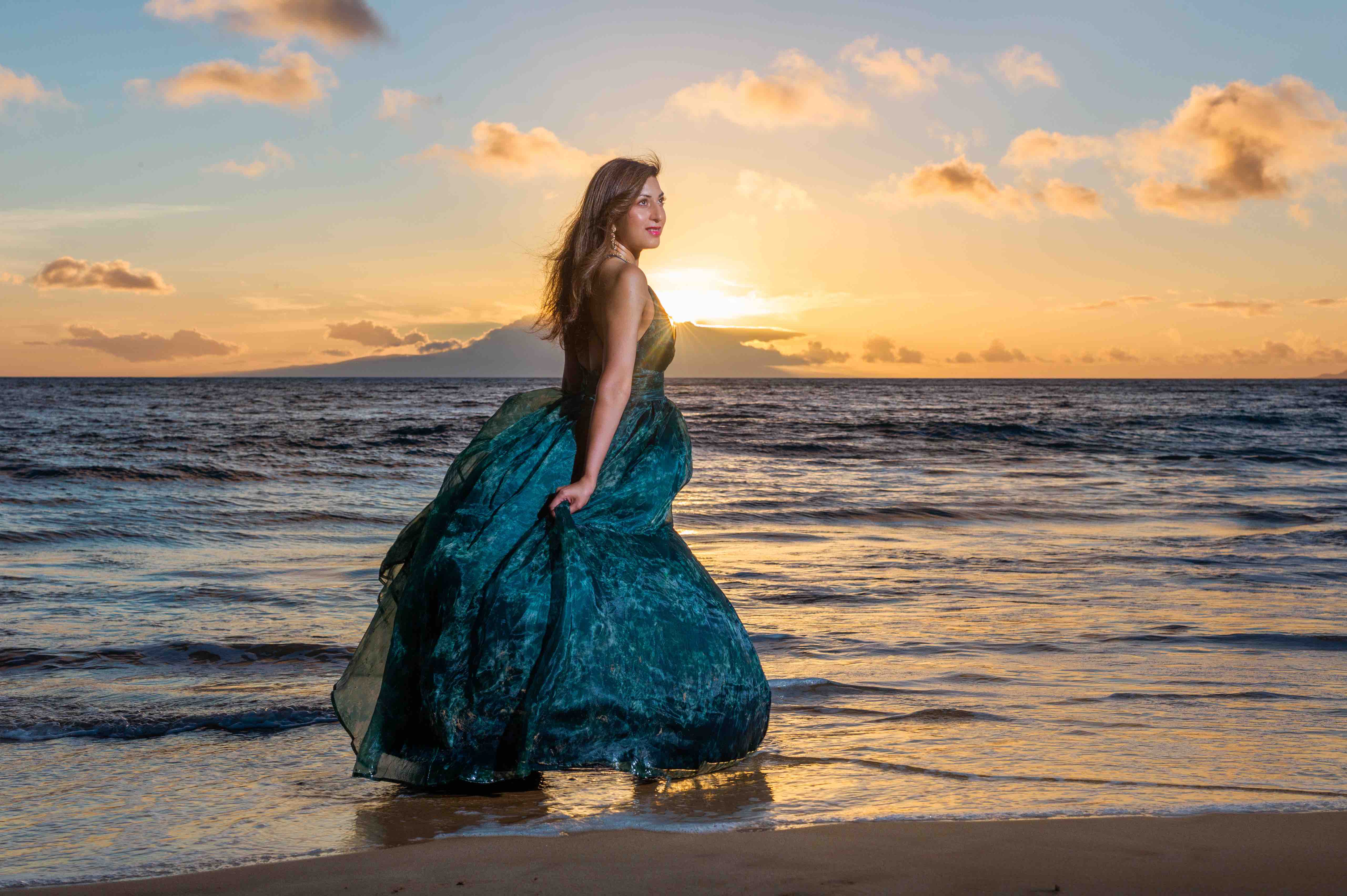 Portrait of a woman wearing a green flying dress at sunset in Wailea Maui. Taken with the Leica 50mm APO Summicron lens. Note the absence of chromatic aberration and purple fringing. The sun appears sharp and crisp.