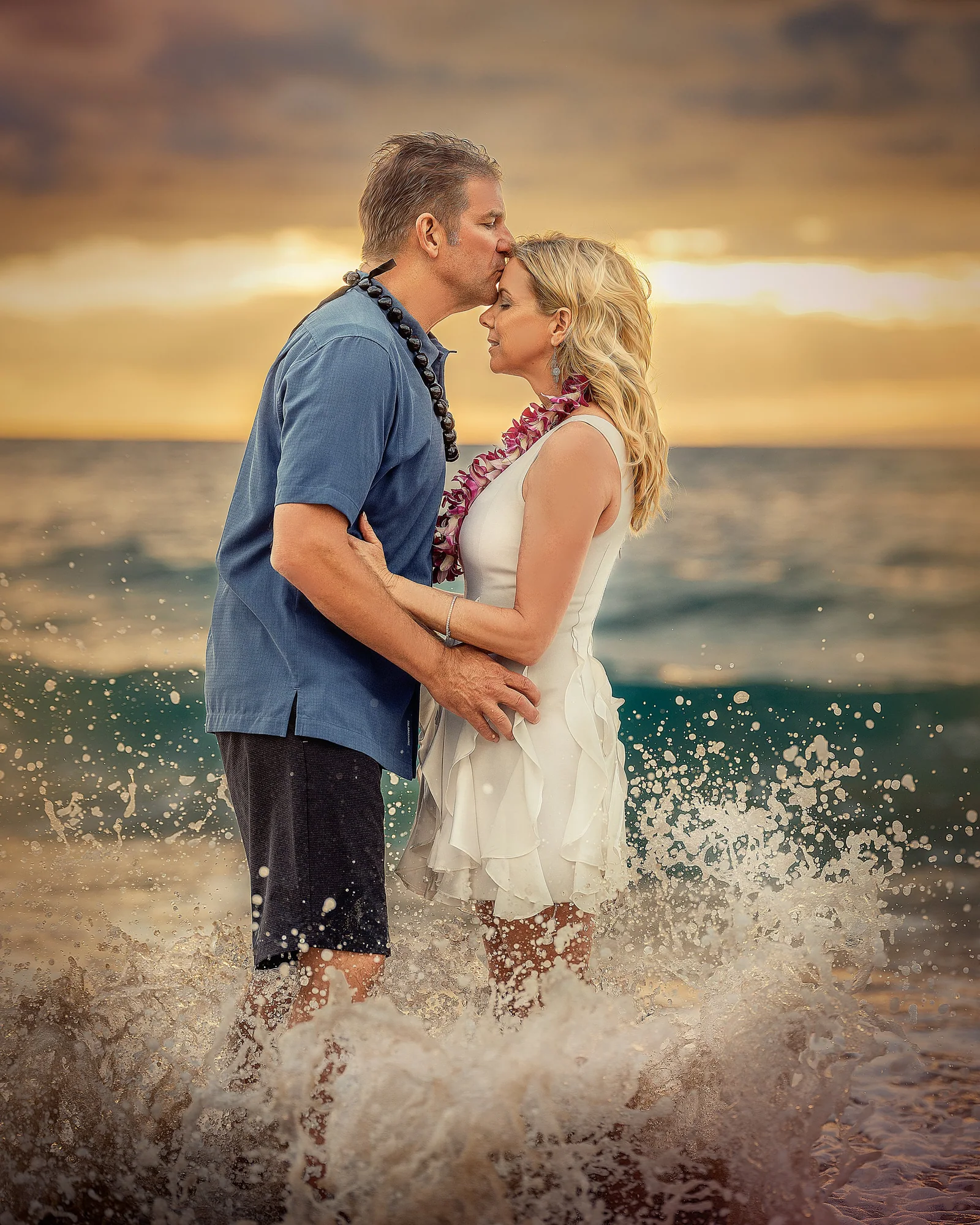 Maui couple standing in breaking surf during a sunset portrait at Wailea