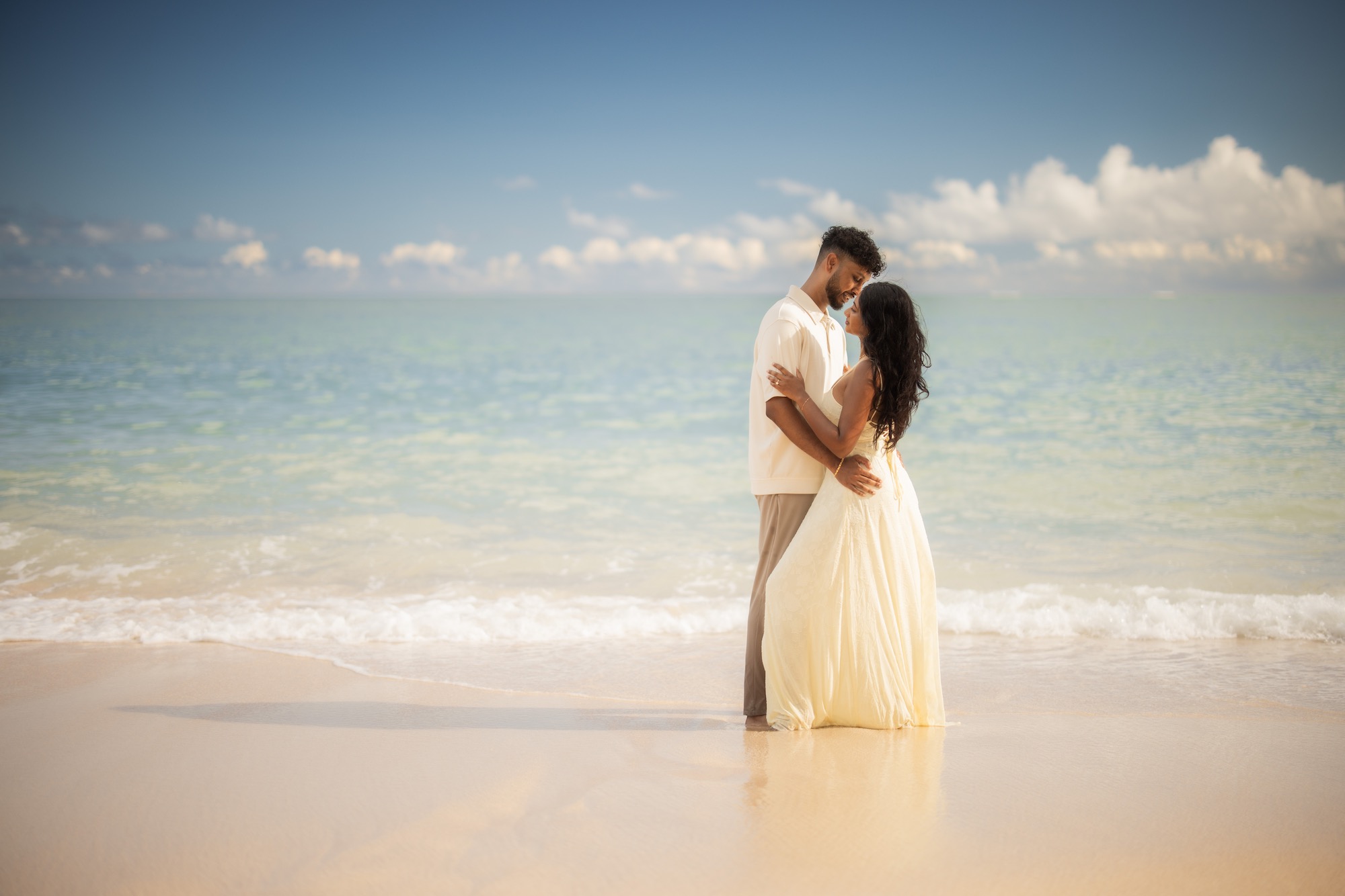 An engaged couple photographed beside turquoise water in Maui