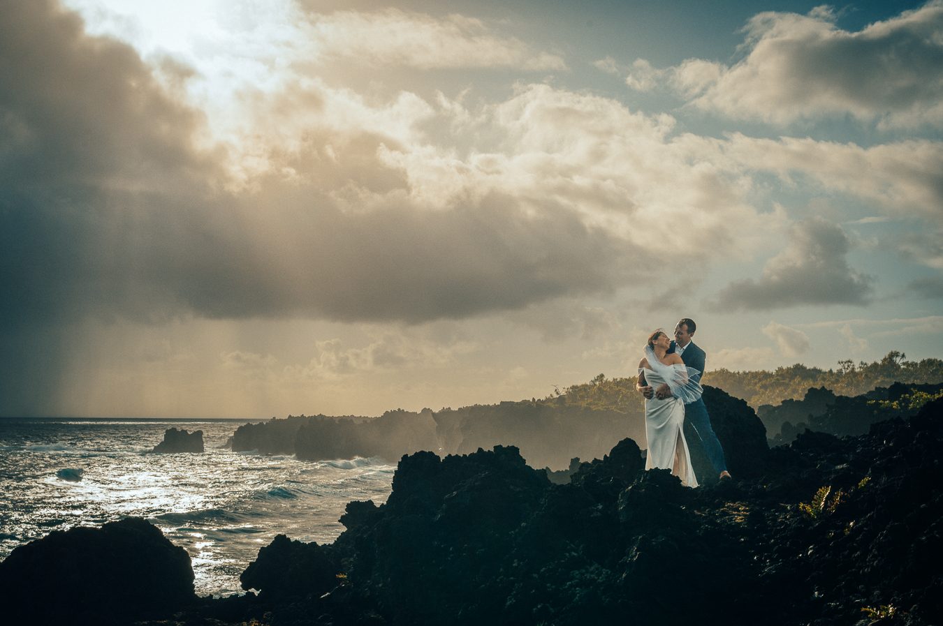 A newly married couple beneath an expansive Maui sunset